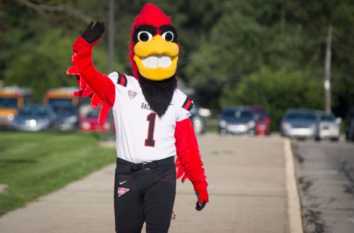 Ball State's mascot, Charlie Cardinal, waves to ongoers.