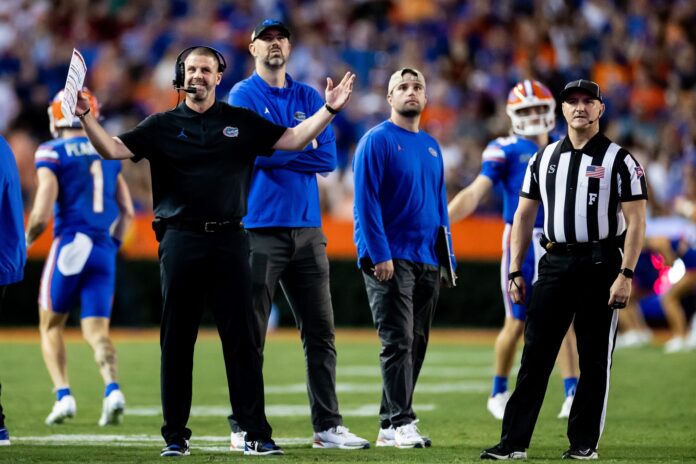 Florida Gators head coach Billy Napier gestures during an official review while others look on.