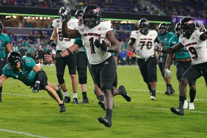 Northern Illinois Huskies running back Antario Brown (1) runs to the end zone ahead of his teammates.