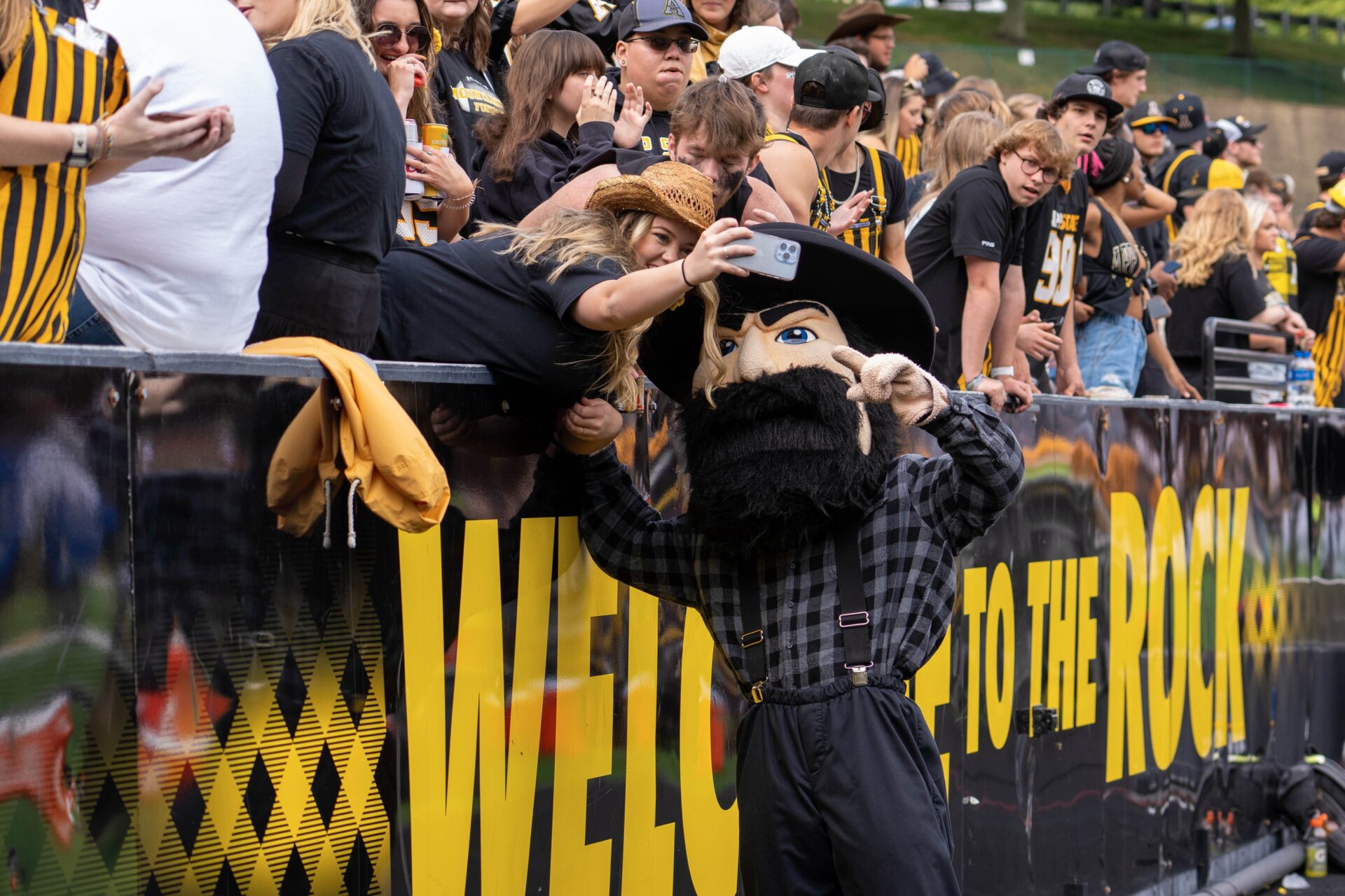 A fan takes a selfie with Appalachian State Mountaineers mascot.