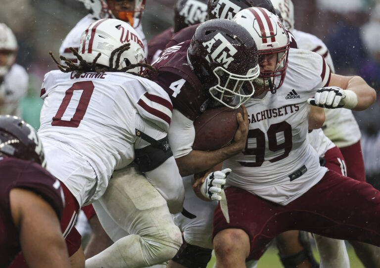 Texas A&M Aggies running back Amari Daniels (4) runs with the ball as Massachusetts Minutemen defensive lineman Marcus Cushnie (0) and defensive lineman Hugo Klages (99) attempt to make a tackle during the fourth quarter at Kyle Field.