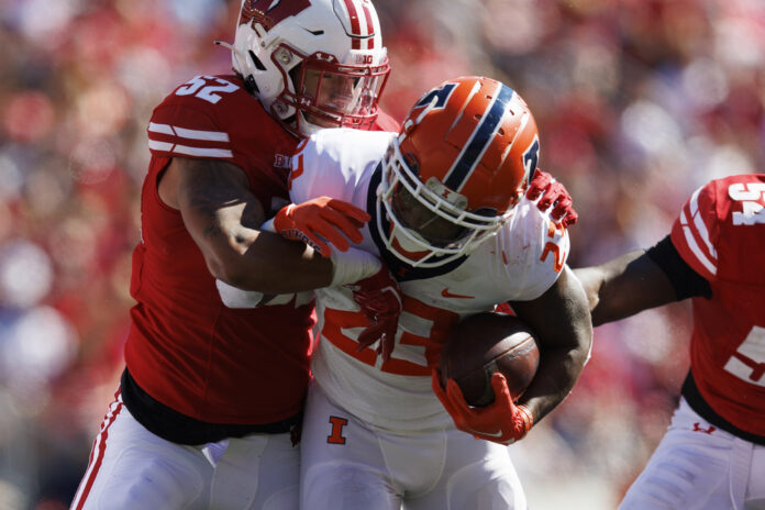 Oct 1, 2022; Madison, Wisconsin, USA; Illinois Fighting Illini running back Reggie Love III (23) is tackled by Wisconsin Badgers linebacker Kaden Johnson (52) during the third quarter at Camp Randall Stadium. Mandatory Credit: Jeff Hanisch-USA TODAY Sports