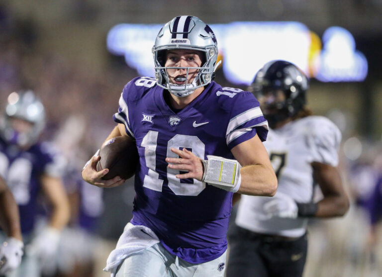 Kansas State Wildcats quarterback Will Howard (18) runs away from several UCF Knights defenders to score a touchdown late in the fourth quarter at Bill Snyder Family Football Stadium.