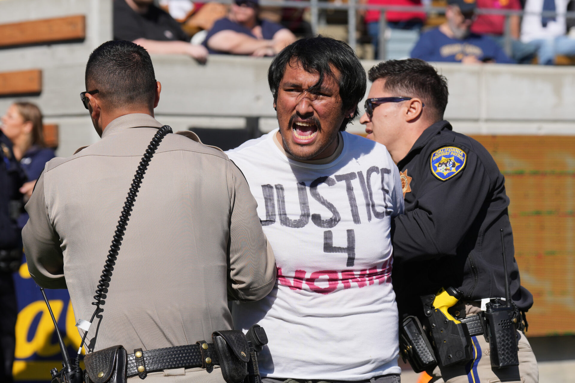 Protestors took to the field to delay the kickoff of the USC-Cal game in protest of the suspended Ivonne del Valle, a UC Berkeley professor.