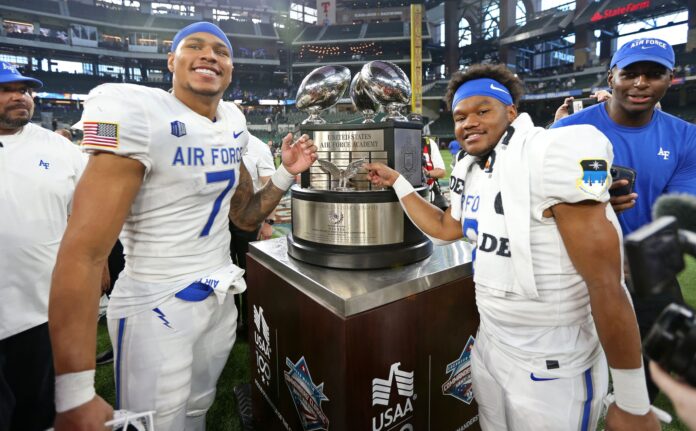 The Air Force Falcons celebrate after beating the Army Black Knights 13-7 to capture the Commanders in Chief trophy at the Commanders’ Classic at Globe Life Field.
