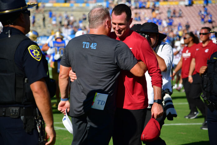 Washington State Cougars head coach Jake Dickert meets with UCLA Bruins head coach Chip Kelly following the game at Rose Bowl.