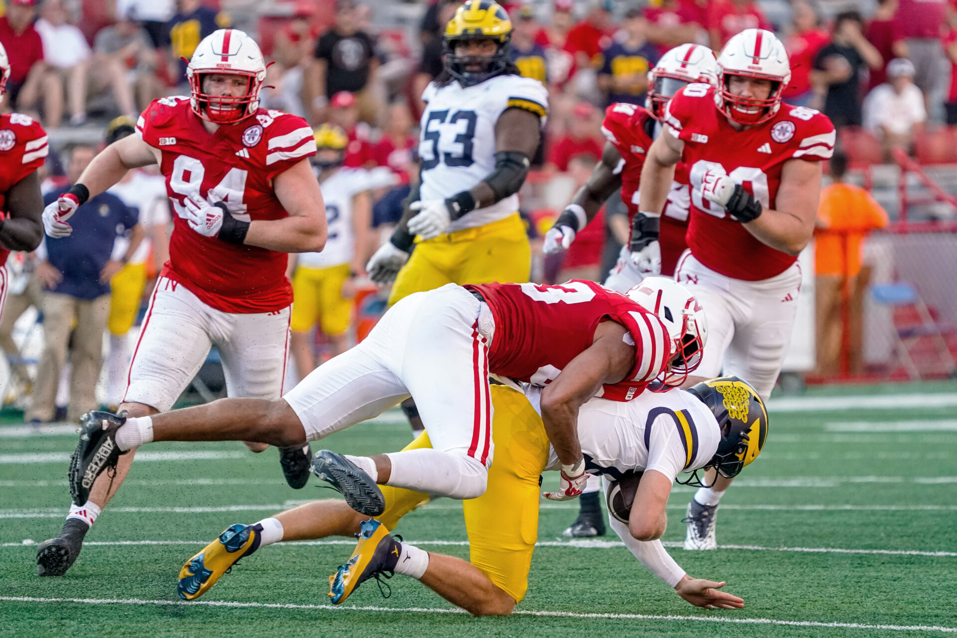Nebraska Cornhuskers linebacker Javin Wright (33) tackles Michigan Wolverines quarterback Davis Warren (16) during the fourth quarter at Memorial Stadium.