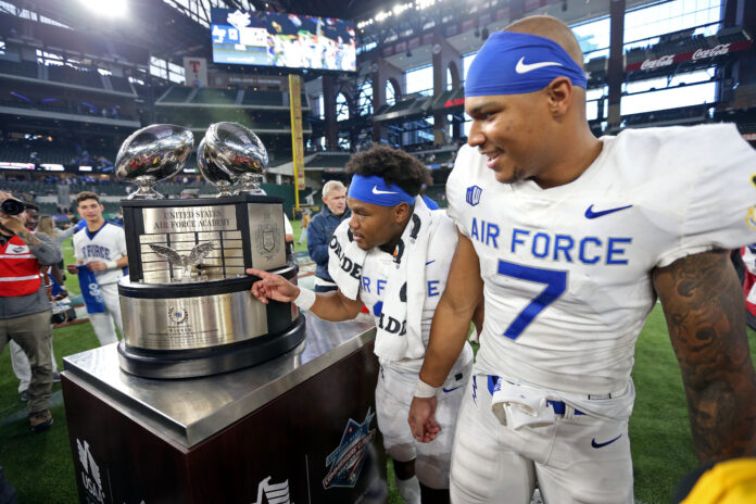 The Air Force Falcons celebrate after beating the Army Black Knights 13-7 to capture the Commanders in Chief trophy at the Commanders Classic at Globe Life Field.