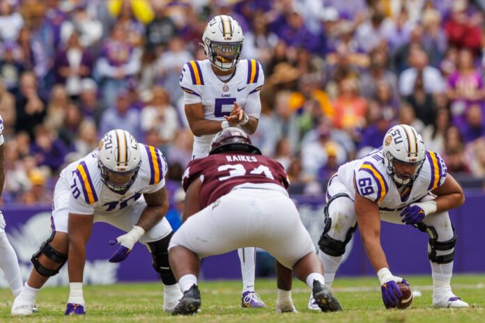 LSU Tigers quarterback Jayden Daniels (5) calls for the ball against Texas A&M Aggies defensive lineman Isaiah Raikes (34) during the second half at Tiger Stadium.