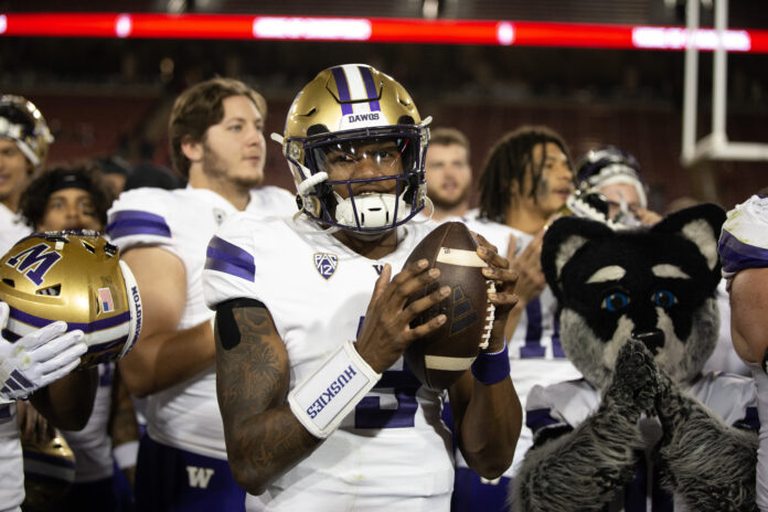 Washington Huskies quarterback Michael Penix Jr. (with ball) and his teammates celebrate their victory over the Stanford Cardinal at Stanford Stadium.