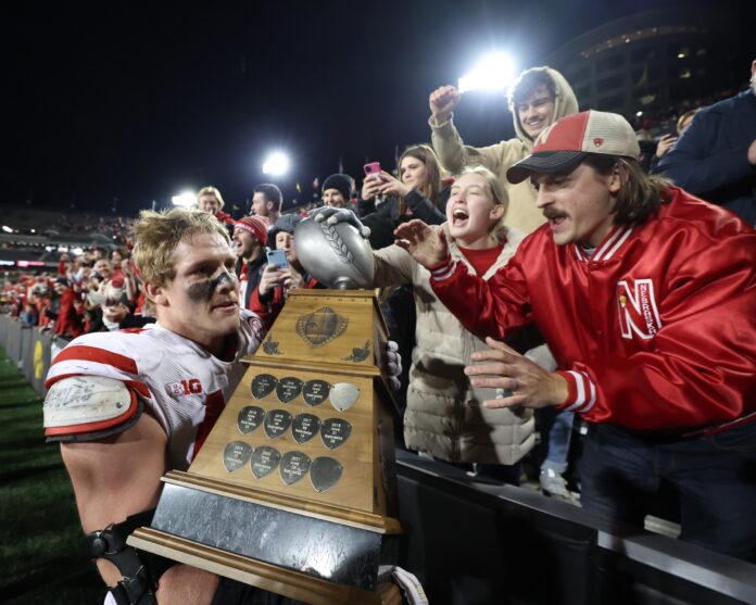 Nebraska Cornhuskers defensive end Garrett Nelson (44) shares the Heroes Trophy with fans after defeating the Iowa Hawkeyes at Kinnick Stadium.