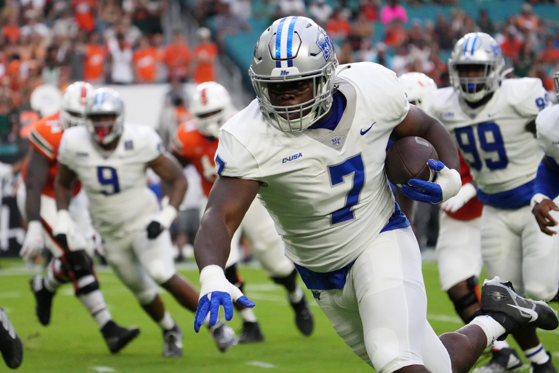 Middle Tennessee Blue Raiders defensive tackle Zaylin Wood (7) runs with the ball for a touchdown after intercepting a batted down pass against the Miami Hurricanes during the first half at Hard Rock Stadium.