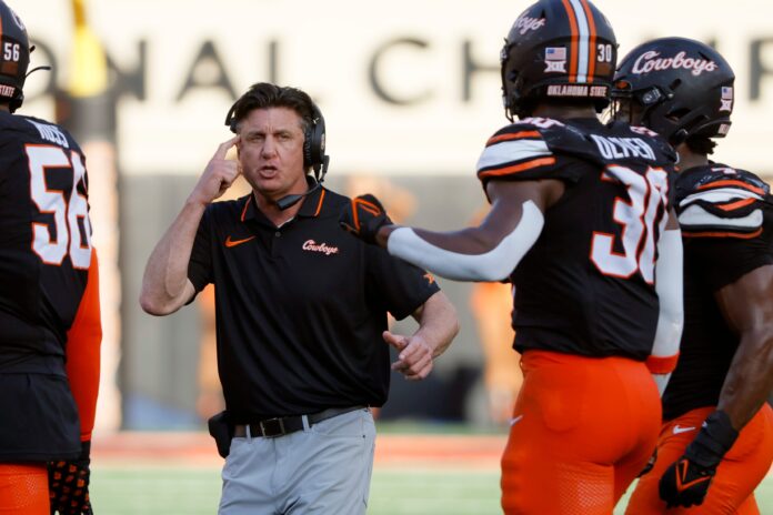 Oklahoma State coach Mike Gundy talks with his players during a Bedlam college football game between the Oklahoma State University Cowboys (OSU) and the University of Oklahoma Sooners (OU) at Boone Pickens Stadium in Stillwater.