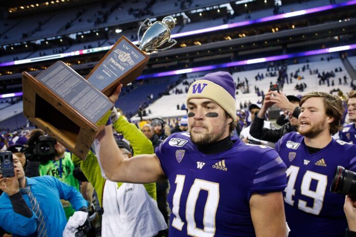 Washington Huskies quarterback Jacob Eason (10) carries the Apple Cup trophy after a win against the Washington State Cougars at Husky Stadium.