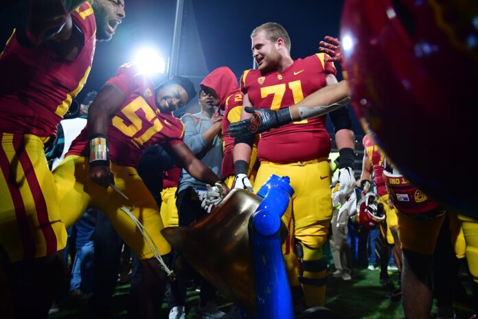 Southern California Trojans defensive lineman Solomon Byrd (51) and offensive lineman Cooper Lovelace (71) celebrate with the victory bell at the Rose Bowl.