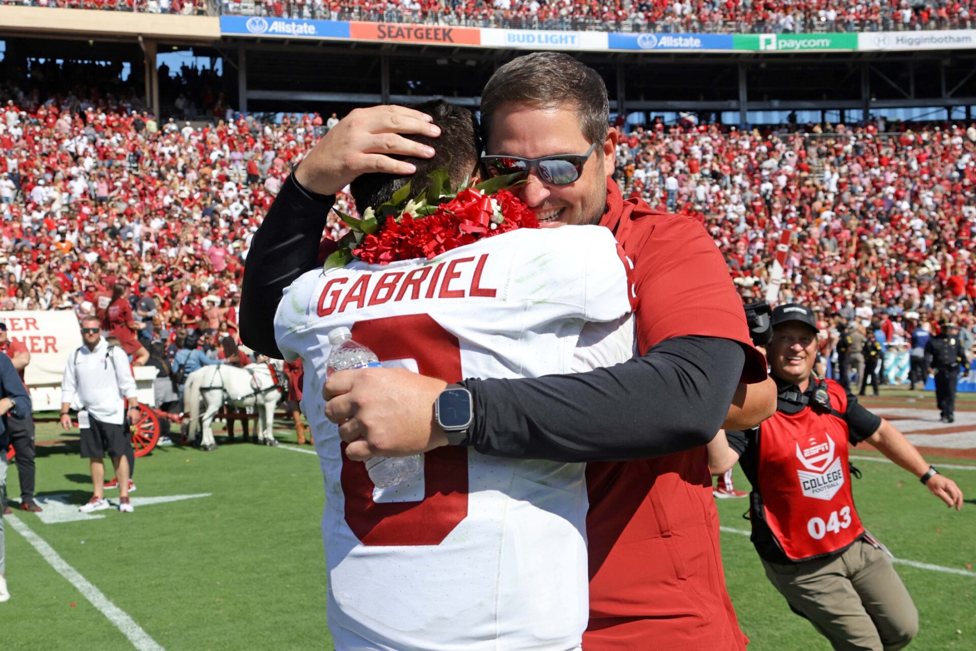 Oklahoma offensive coordinator Jeff Lebby hugs quarterback Dillon Gabriel (8) during the Red River Rivalry college football game between the University of Oklahoma Sooners (OU) and the University of Texas (UT) Longhorns at the Cotton Bowl.