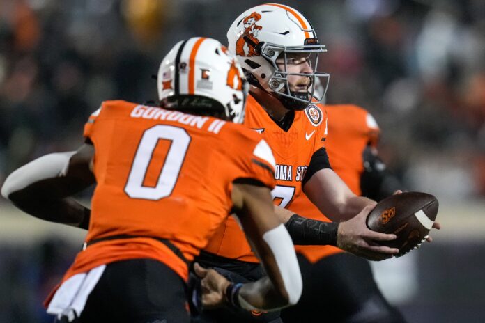 Oklahoma State Cowboys quarterback Alan Bowman (7) hands off to running back Ollie Gordon II (0) in the second quarter of the NCAA Big12 football game between the Oklahoma State Cowboys and the Cincinnati Bearcats