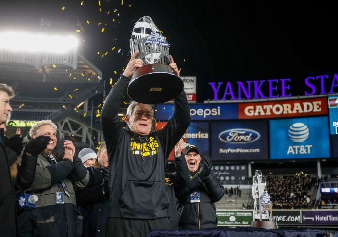 Iowa head football coach Kirk Ferentz raises the 2017 Pinstripe Bowl trophy after leading the Hawkeyes to a 27-20 win over Boston College in the 2017 Pinstripe Bowl at Yankee Stadium in Bronx, NY on Wednesday, Dec. 27, 2017.