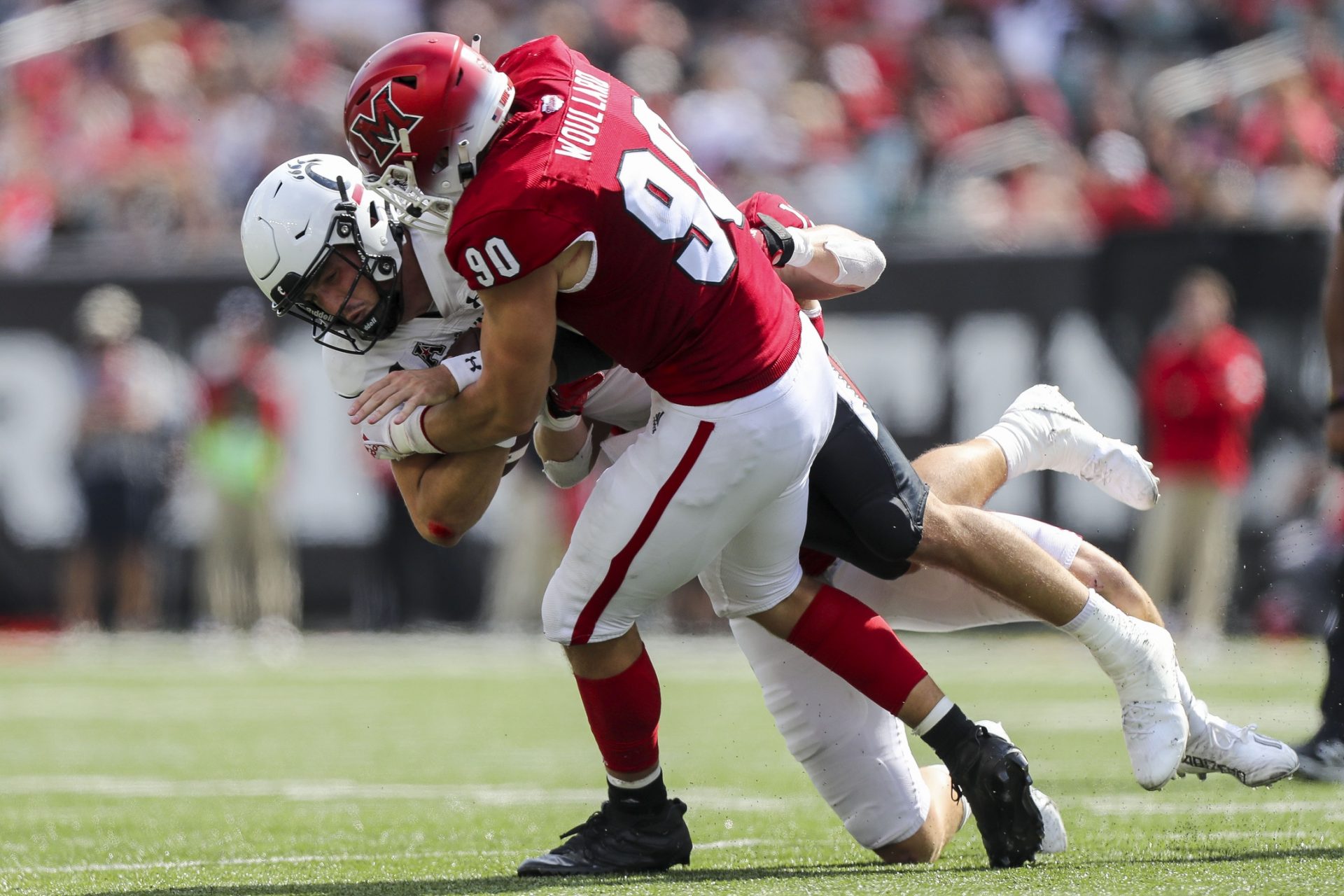 Miami Redhawks defensive lineman Caiden Woullard (90) brings down Cincinnati Bearcats quarterback Ben Bryant (6) in the second half at Paycor Stadium.