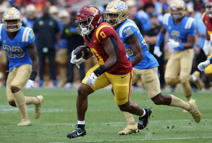 USC Trojans running back MarShawn Lloyd (0) runs against UCLA Bruins defensive back Alex Johnson (36) during the third quarter at United Airlines Field at Los Angeles Memorial Coliseum.
