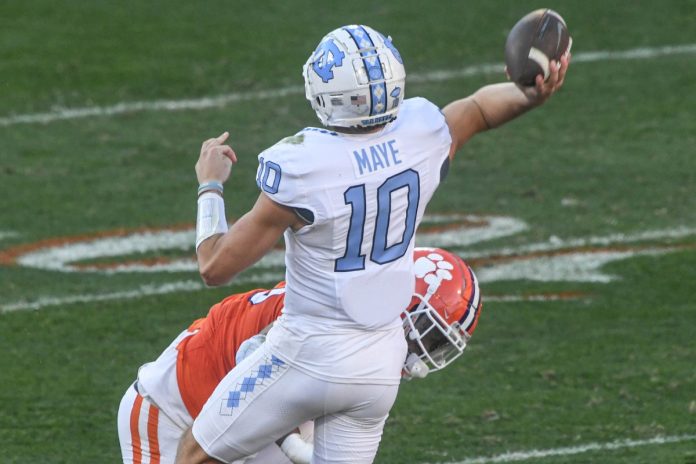 North Carolina Tar Heels quarterback Drake Maye (10) throws a pass to wide receiver J.J. Jones (not pictured) for a touchdown against Clemson Tigers defensive tackle Tyler Davis (13) during the first quarter at Memorial Stadium.