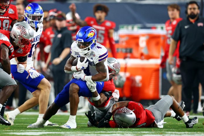 Kansas Jayhawks running back Devin Neal (4) runs with the ball during the first quarter against the UNLV Rebels in the Guaranteed Rate Bowl at Chase Field.