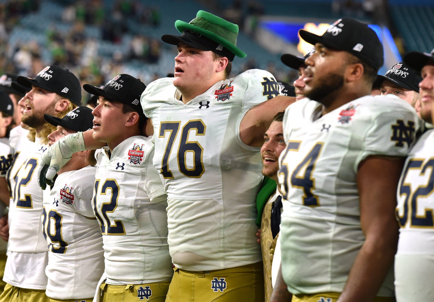 Notre Dame Fighting Irish quarterback Tyler Buchner (12) with teammate offensive lineman Joe Alt (76) and the team leprechaun mascot Ryan Coury sing the School's Alma mater after their victory over South Carolina in the Gator Bowl.