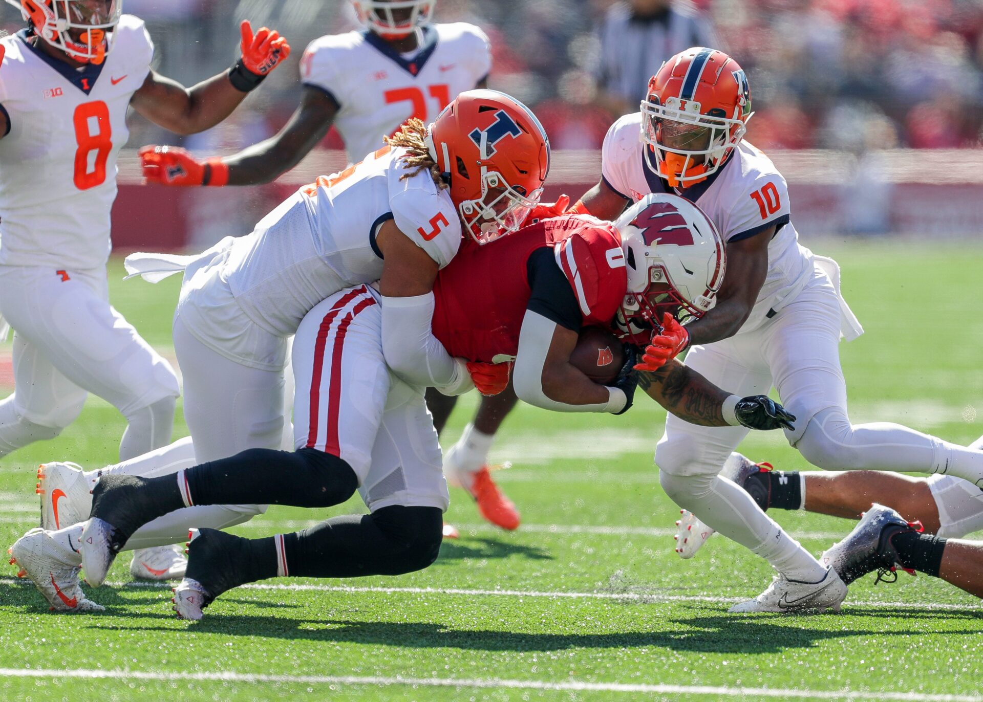 Illinois linebacker Calvin Hart Jr. (5) and defensive back Tahveon Nicholson (10) tackle Wisconsin running back Braelon Allen