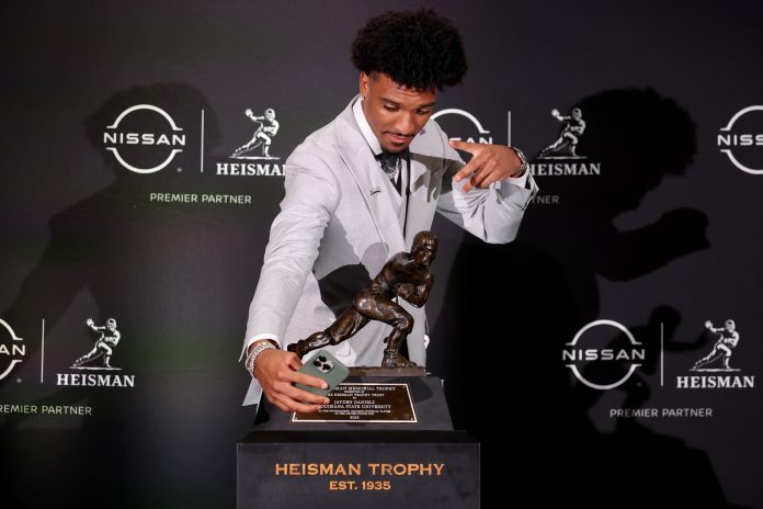 LSU Tigers quarterback Jayden Daniels takes a selfie with the Heisman trophy during a press conference in the Astor ballroom at the New York Marriott Marquis after winning the Heisman trophy.