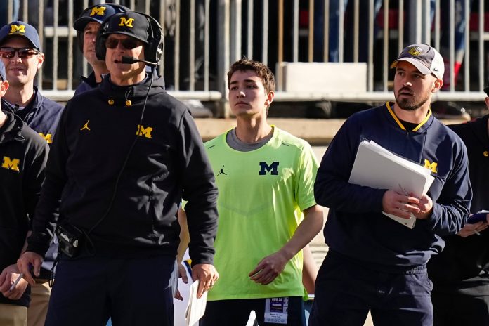 Michigan Wolverines head coach Jim Harbaugh watches from the sideline beside off-field analyst Connor Stalions, right, during the NCAA football game against the Ohio State Buckeyes at Ohio Stadium.