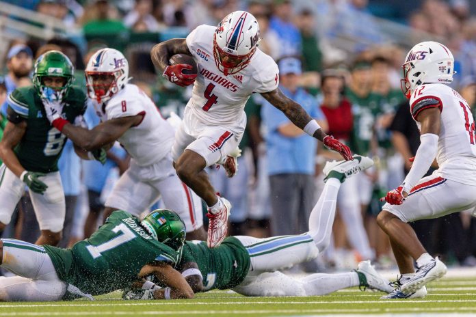 Sep 2, 2023; New Orleans, Louisiana, USA; South Alabama Jaguars wide receiver Caullin Lacy (4) leaps over Tulane Green Wave safety Bailey Despanie (32) and defensive back Lance Robinson (7) during the first half at Yulman Stadium. Mandatory Credit: Stephen Lew-USA TODAY Sports