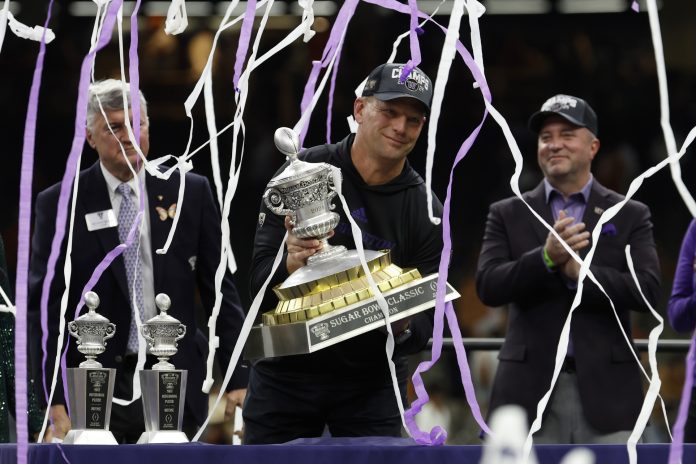 Washington Huskies head coach Kalen DeBoer holds the Sugar Bowl championship trophy after the game against the Texas Longhorns in the 2024 Sugar Bowl college football playoff semifinal game at Caesars Superdome.