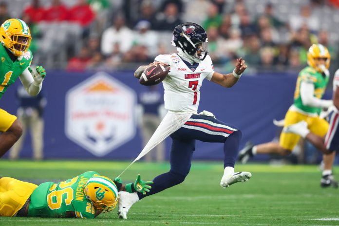 Liberty Flames quarterback Kaidon Salter (7) evades a tackle by Oregon Ducks linebacker Devon Jackson (26) during the second half in the 2024 Fiesta Bowl at State Farm Stadium.