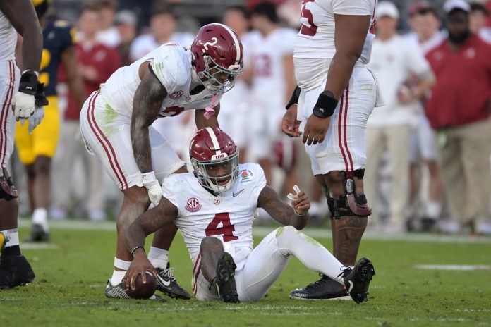 Alabama Crimson Tide quarterback Jalen Milroe (4) is helped up by running back Jase McClellan (2) during the second half against the Michigan Wolverines in the 2024 Rose Bowl college football playoff semifinal game at Rose Bowl.