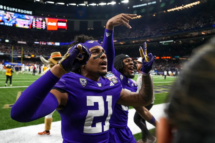 Washington Huskies cornerback Dyson McCutcheon (21) mocks Texas fans after the Sugar Bowl College Football Playoff semifinals game against the Texas Longhorns at the Caesars Superdome on Monday, Jan. 1, 2024 in New Orleans, Louisiana.