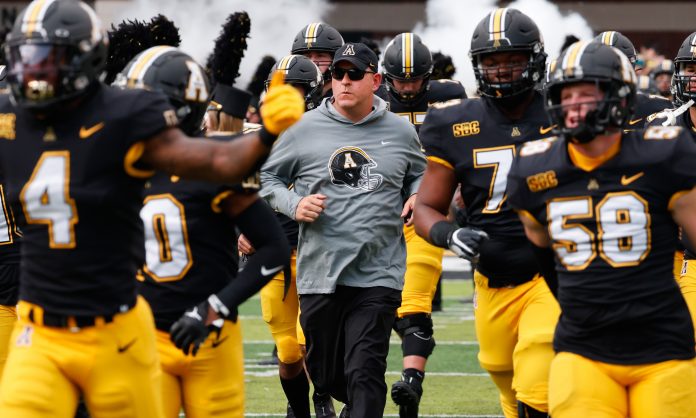 Sep 17, 2022; Boone, North Carolina, USA; Appalachian State Mountaineers head coach Shawn Clark (middle) runs on the field before the game against the Troy Trojans at Kidd Brewer Stadium. Mandatory Credit: Reinhold Matay-USA TODAY Sports