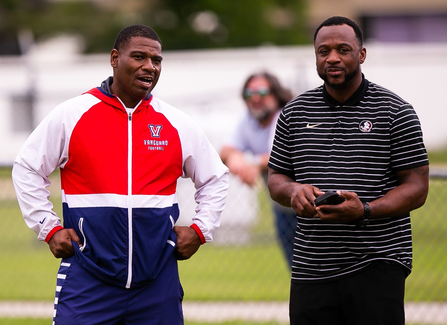 Vanguard Head Football Coach Edwin Farmer, left, talks with Florida State Defensive Back Coach Patrick Surtain, right, Wednesday. The Vanguard Knights held a Spring football practice at Booster Stadium Wednesday afternoon, May 24, 2023 in Ocala, FL. The Knights played Manatee High School in their Spring football matchup. [Doug Engle/Ocala Star Banner]2023