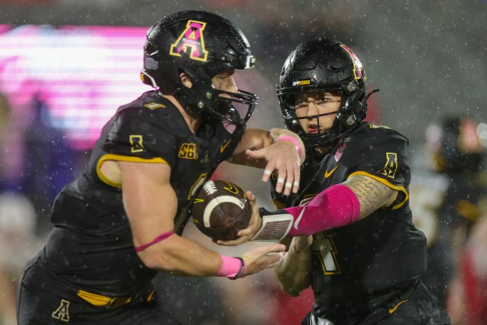Dec 16, 2023; Orlando, FL, USA; Appalachian State Mountaineers quarterback Joey Aguilar (4) hands off to Appalachian State Mountaineers running back Anderson Castle (1) against the Miami (OH) Redhawks in the third quarter in the third quarter during the Avocados from Mexico Cure Bowl at FBC Mortgage Stadium. Mandatory Credit: Nathan Ray Seebeck-USA TODAY Sports