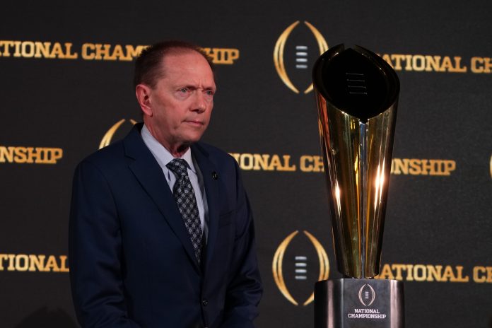 Jan 9, 2024; Houston, TX, USA; College Football Playoff senior director of communications Brett Daniels poses with CFP National Championship trophy at press conference at JW Marriot Houston by the Galleria. Mandatory Credit: Kirby Lee-USA TODAY Sports