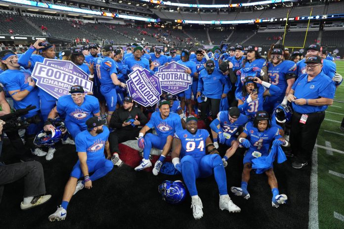 Boise State Broncos players pose after 44-20 victory over the UNLV Rebels in the Mountain West Championship at Allegiant Stadium.