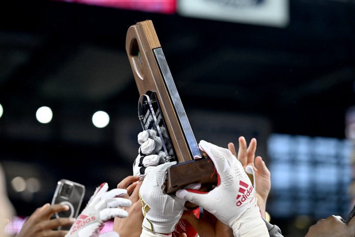 Dec 2, 2023; Detroit, MI, USA; Miami (OH) Redhawks players hold up the MAC Championship trophy after defeating the Toledo Rockets at Ford Field. Mandatory Credit: Lon Horwedel-USA TODAY Sports