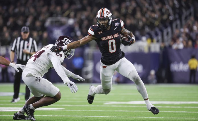 Dec 27, 2023; Houston, TX, USA; Oklahoma State Cowboys running back Ollie Gordon II (0) runs with the ball as Texas A&M Aggies linebacker Chris Russell Jr. (24) attempts to make a tackle during the first quarter at NRG Stadium. Mandatory Credit: Troy Taormina-USA TODAY Sports
