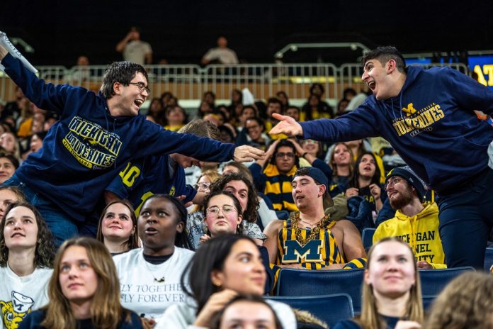 Fans celebrate a University of Michigan touchdown during a student watch party at the Crisler Center on the University of Michigan campus in Ann Arbor on Monday.