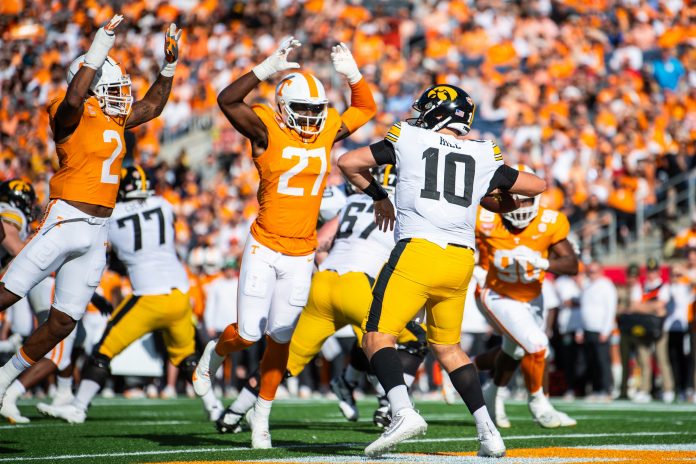 Iowa Hawkeyes quarterback Deacon Hill (10) throws the ball over Tennessee Volunteers defensive lineman James Pearce Jr. (27) in the third quarter at Camping World Stadium.