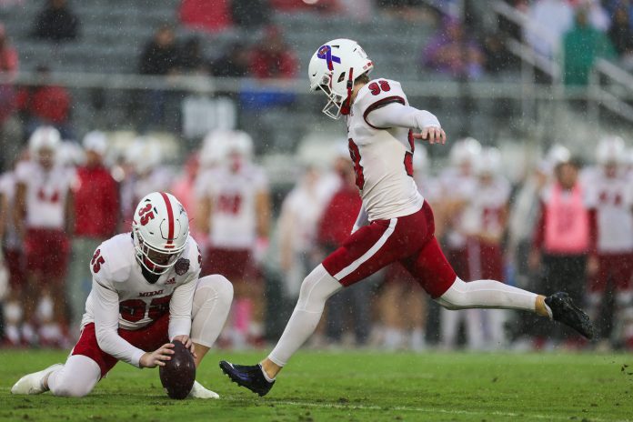 Miami (OH) Redhawks place kicker Graham Nicholson (98) attempts a field goal held by place kicker Alec Bevelhimer (35) against the Appalachian State Mountaineers in the first quarter during the Avocados from Mexico Cure Bowl at FBC Mortgage Stadium.