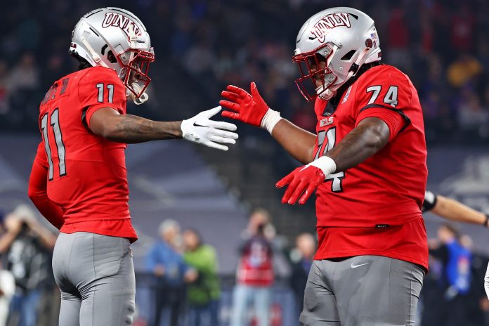 UNLV Rebels wide receiver Ricky White (11) celebrates with offensive lineman Jalen St. John (74) after scoring a touchdown during the third quarter against the Kansas Jayhawks in the Guaranteed Rate Bowl at Chase Field.