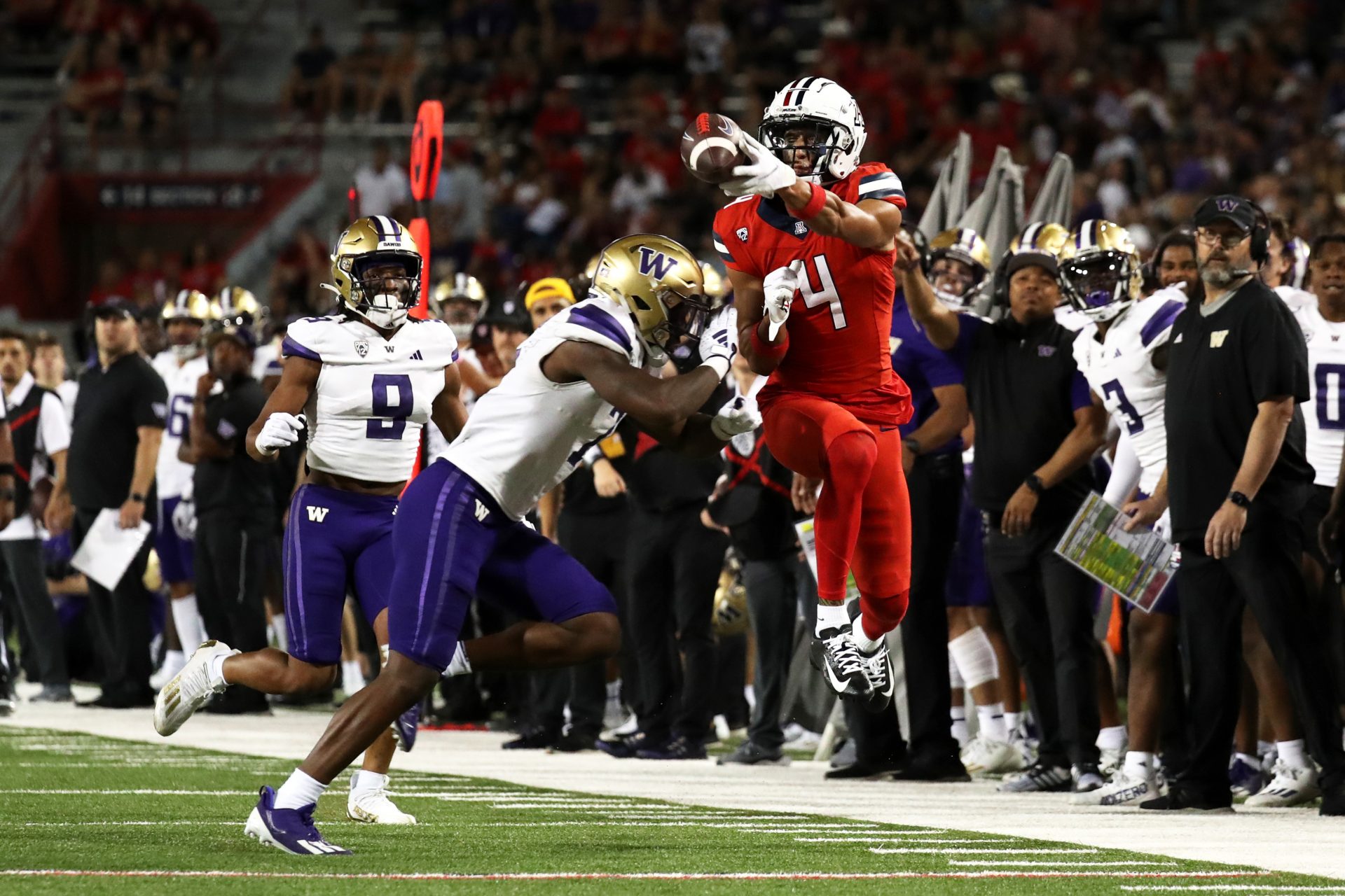 Sep 30, 2023; Tucson, Arizona, USA; Arizona Wildcats wide receiver Tetairoa McMillan (4) gets hit by Washington Huskies cornerback Dominique Hampton (7) while attempting to catch a pass in the second half at Arizona Stadium. Mandatory Credit: Zachary BonDurant-USA TODAY Sports