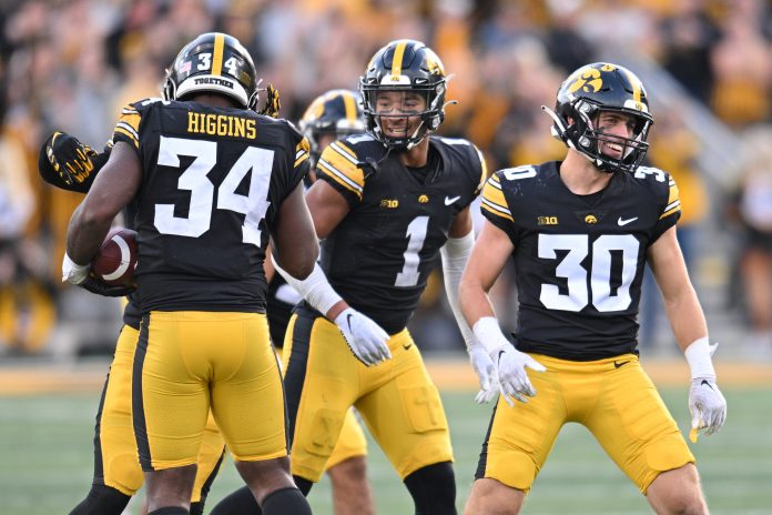Oct 7, 2023; Iowa City, Iowa, USA; Iowa Hawkeyes linebacker Jay Higgins (34) and defensive back Xavier Nwankpa (1) and defensive back Quinn Schulte (30) react after an interception by Higgins against the Purdue Boilermakers during the fourth quarter at Kinnick Stadium. Mandatory Credit: Jeffrey Becker-USA TODAY Sports
