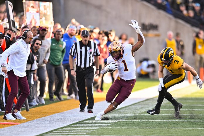 Oct 21, 2023; Iowa City, Iowa, USA; Minnesota Golden Gophers running back Darius Taylor (1) stays in bounds after the catch as Iowa Hawkeyes defensive back Cooper DeJean (3) chases and head coach P.J. Fleck (left) looks on during the third quarter at Kinnick Stadium. Mandatory Credit: Jeffrey Becker-USA TODAY Sports