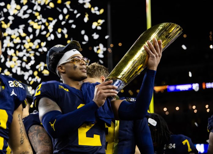 Michigan Wolverines defensive back Will Johnson (2) celebrates with the championship trophy after defeating the Washington Huskies during the 2024 College Football Playoff national championship game at NRG Stadium.